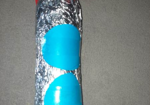 Srebrna rakieta z niebieski kołami wykonana przez dziecko
